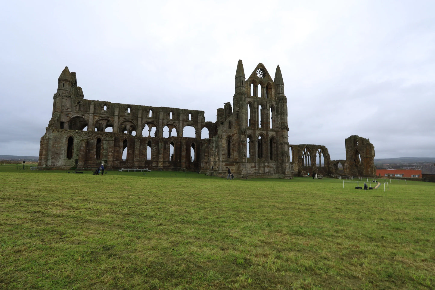 Ruins of historic Whitby Abbey on green field under cloudy sky, Yorkshire landscape photography