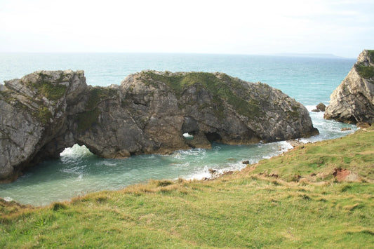 British coastal landscape with rocky cliffs and grassy foreground at turquoise sea