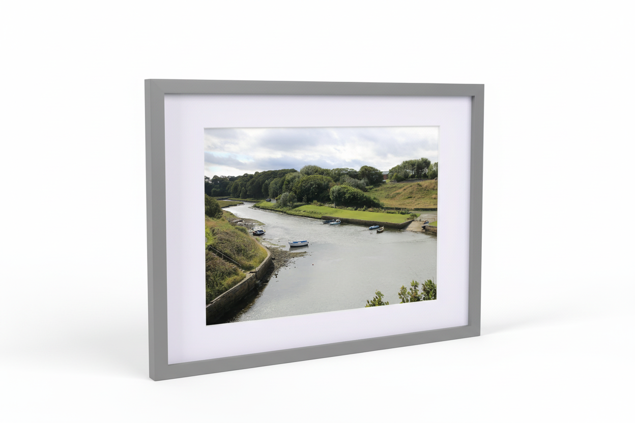 Framed landscape print of a calm river with moored boats and lush green trees under a cloudy sky