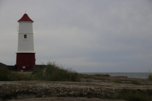Berwick Lighthouse in Northumberland with red and white tower on cloudy day, coastal landscape photography