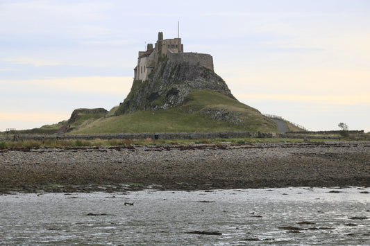 Lindisfarne Castle on rocky hill overlooking tidal shore in Northumberland, British landscape photography