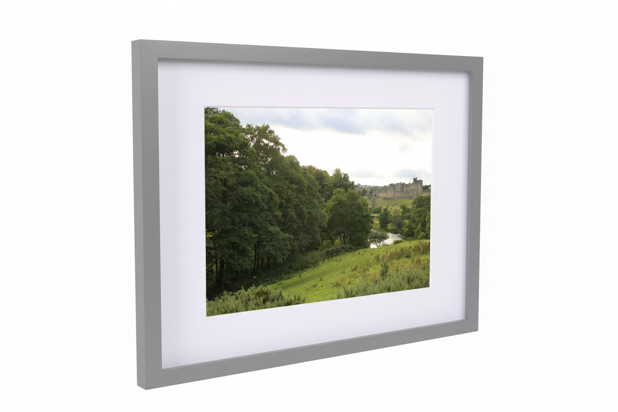 Framed fine art print of Alnwick Castle and surrounding greenery under cloudy sky