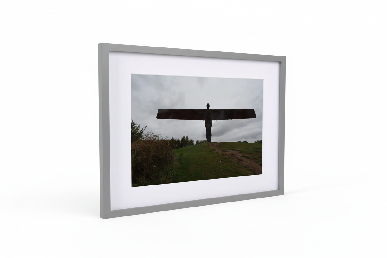 Framed print of Angel of the North sculpture on a grassy hill under cloudy sky