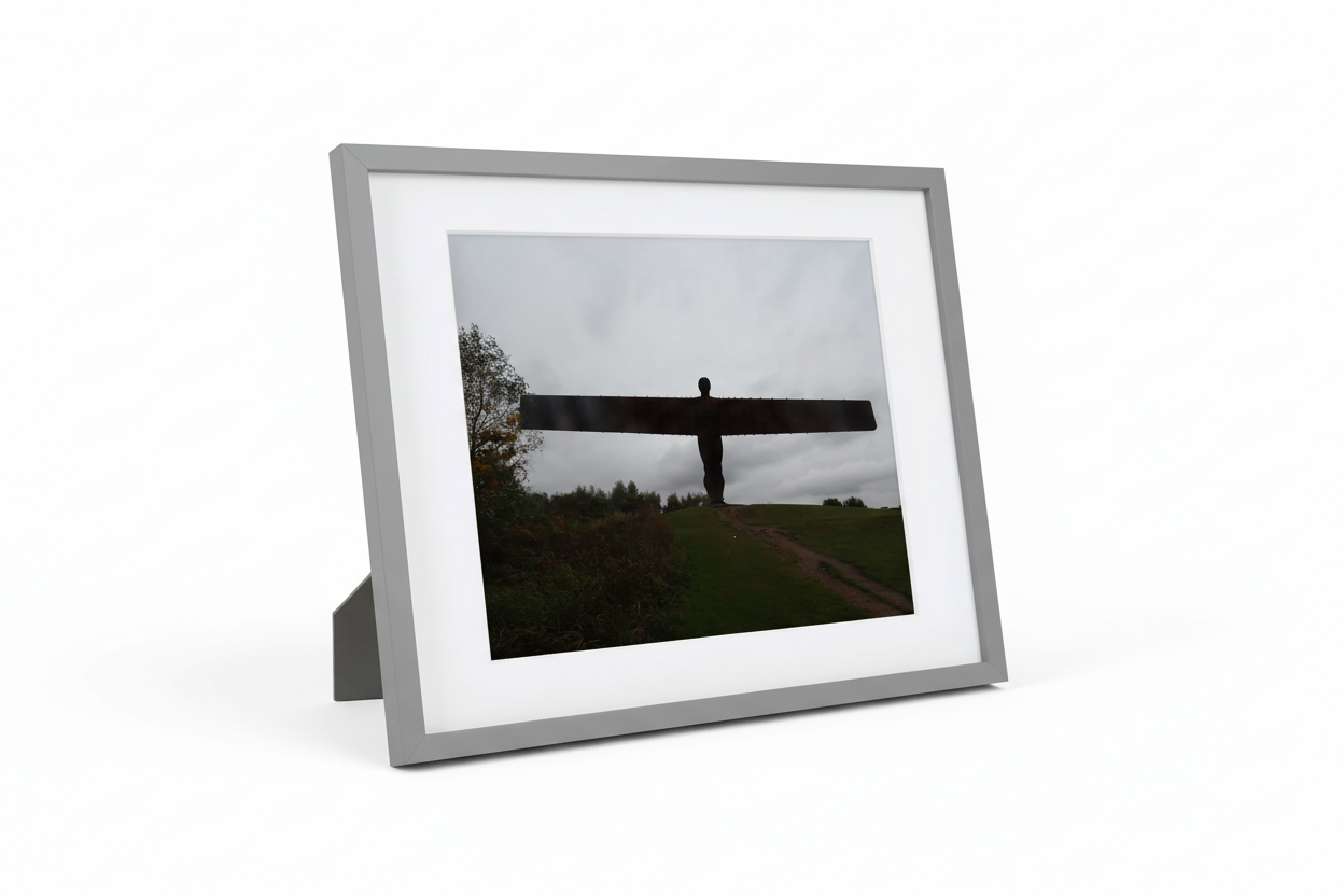 Framed print photo of Angel of the North sculpture on grassy hill under cloudy sky