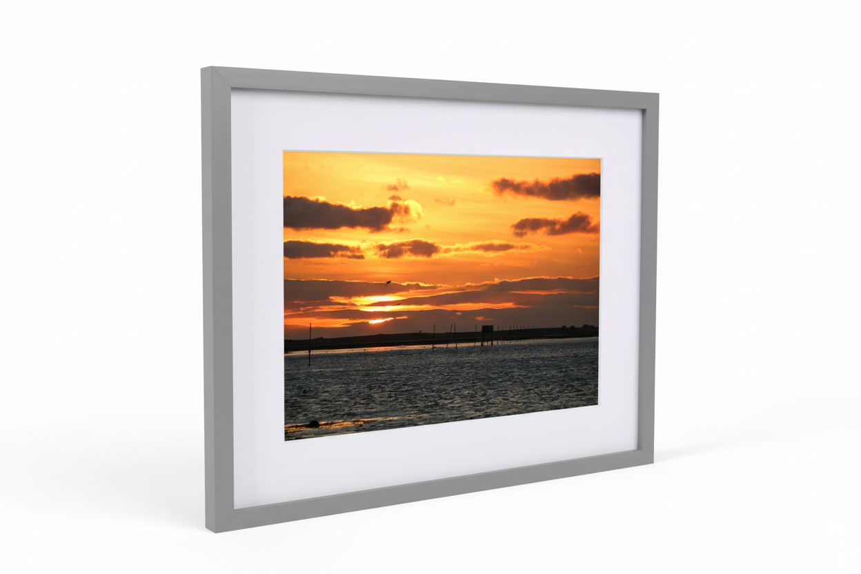 Framed photo print of Lindisfarne Causeway at sunset with vibrant orange sky and calm sea